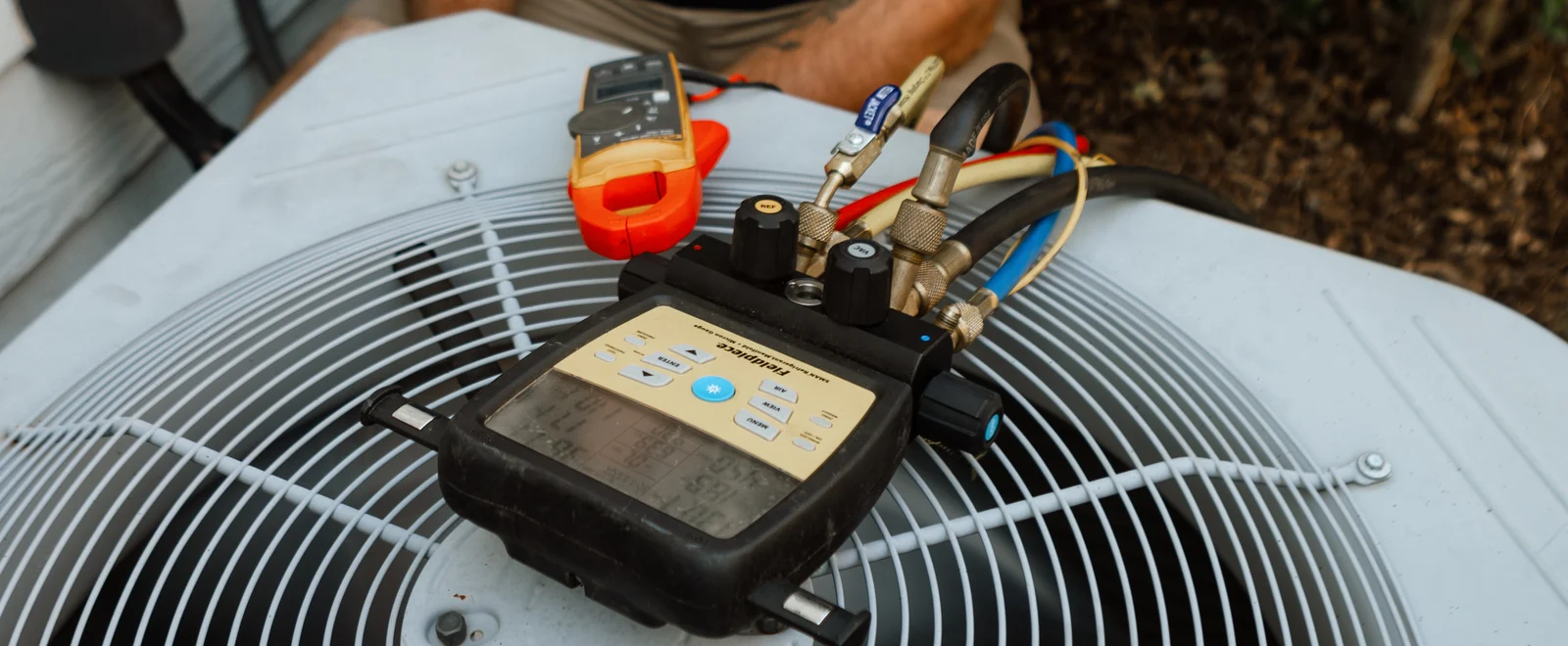 Neighbors Heating and Air technician taking refrigerant readings on an outdoor AC unit